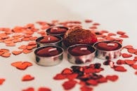 这款心形红蜡烛周围装饰着心形图案，非常适合情人节庆祝活动