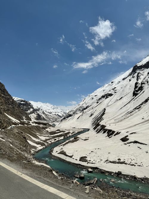 Free A breathtaking view of a winding river through snowy Himalayan mountains under a bright blue sky. Stock Photo