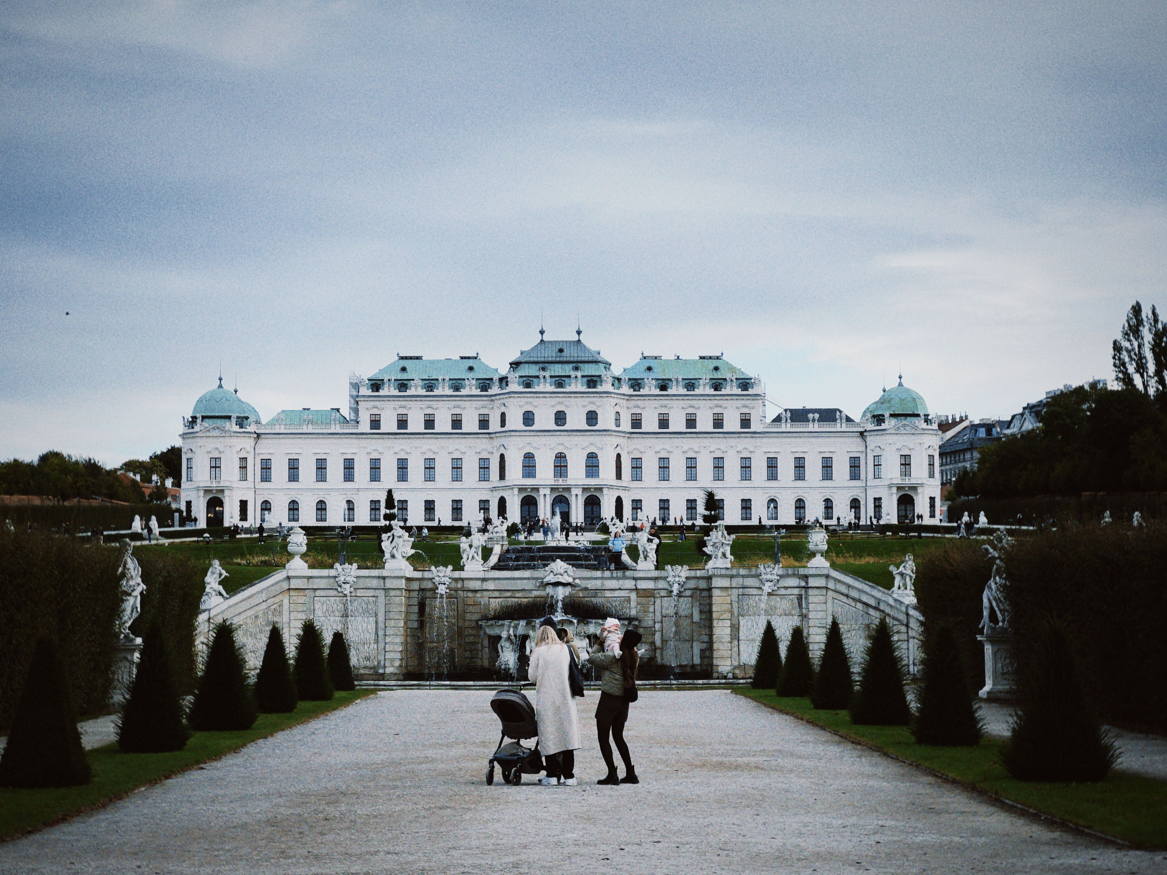 Familie mit Kinderwagen vor dem Schloss Belvedere in Wien