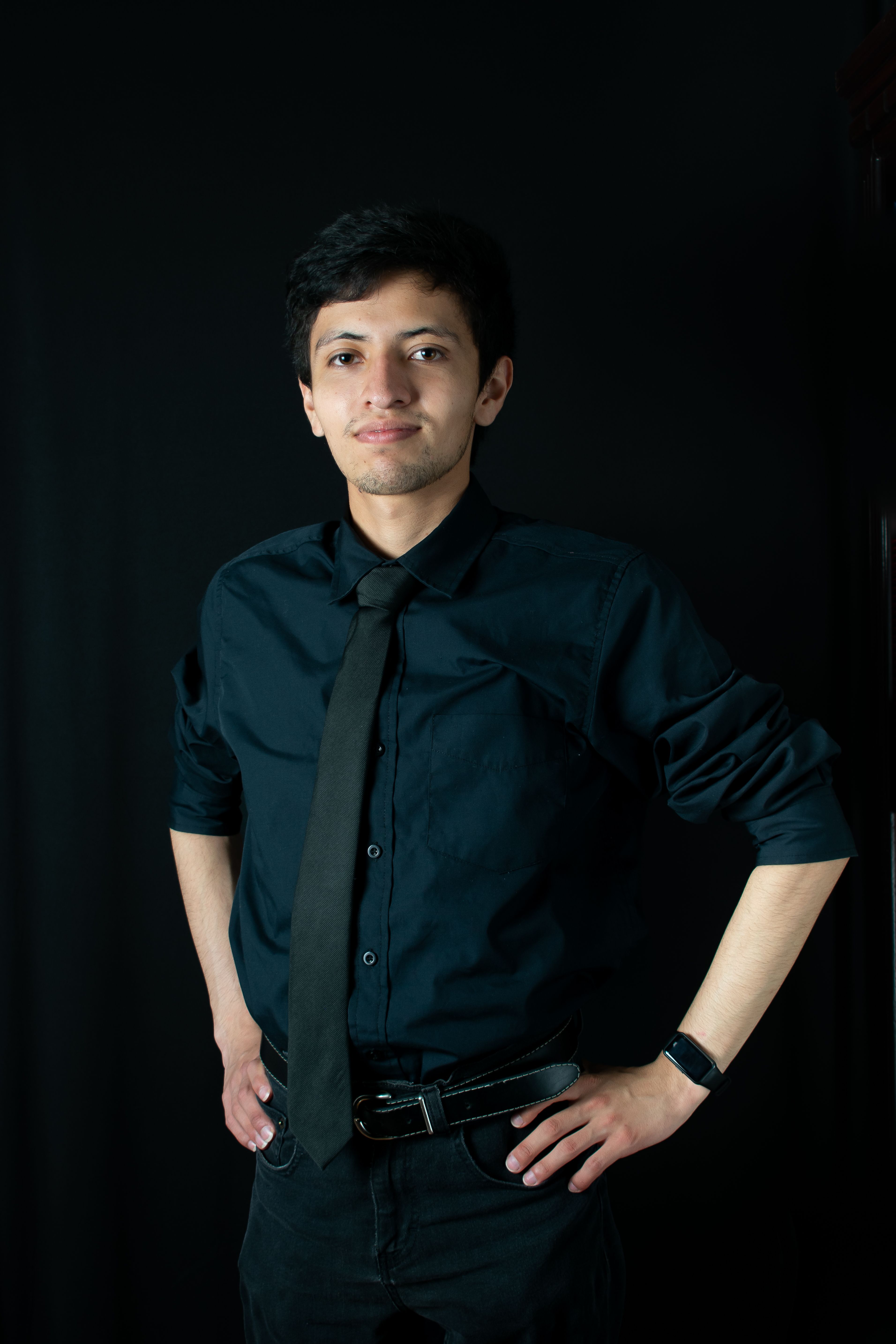 Studio portrait of a young man in formal attire with a confident pose.