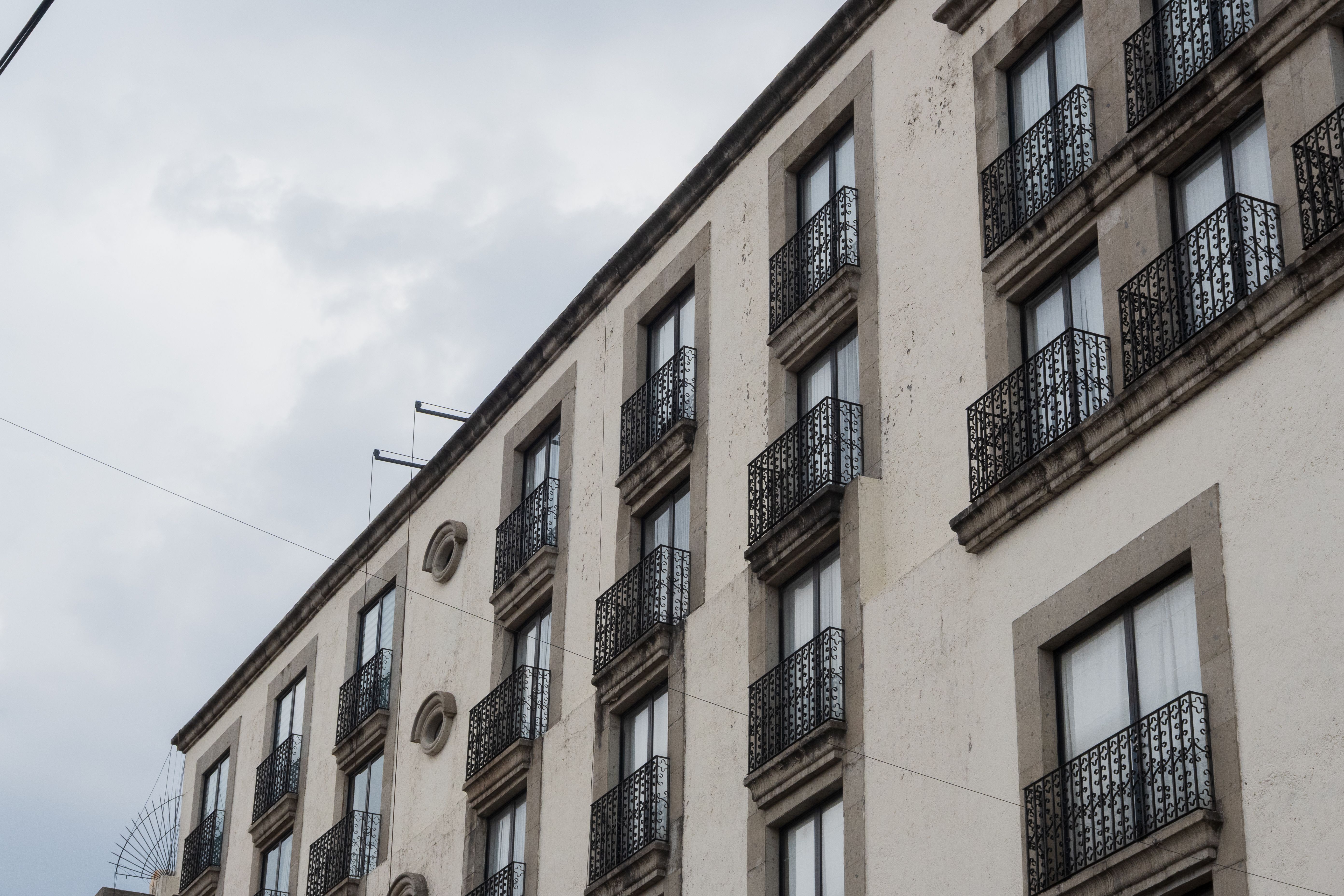 A classic building facade with ornate ironwork balconies in Toluca de Lerdo, Mexico.