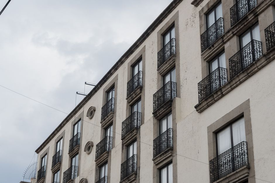 Fachada de un edificio clásico con balcones de hierro forjado ornamentados en Toluca de Lerdo, México.