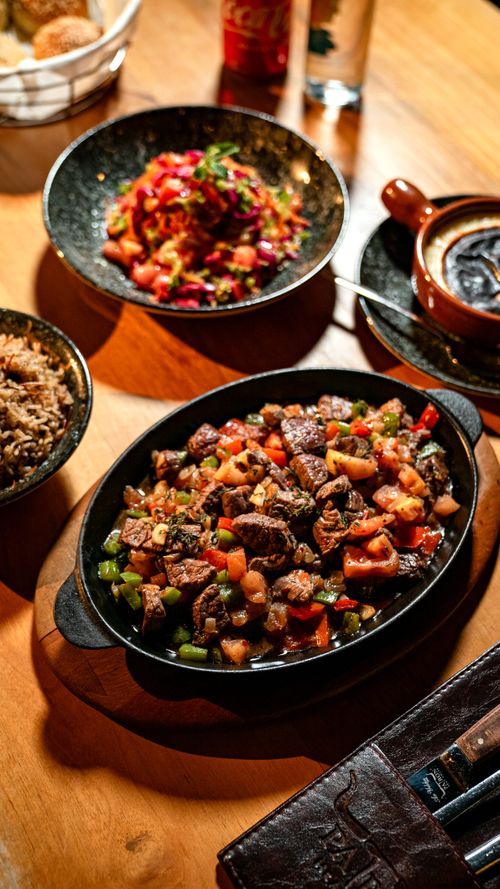 Free A vibrant spread of Mexican dishes featuring meats, rice, and salsas on a warm-toned table. Stock Photo