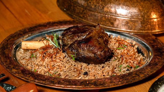 A sumptuous lamb shank served on a bed of aromatic basmati rice with herbs.