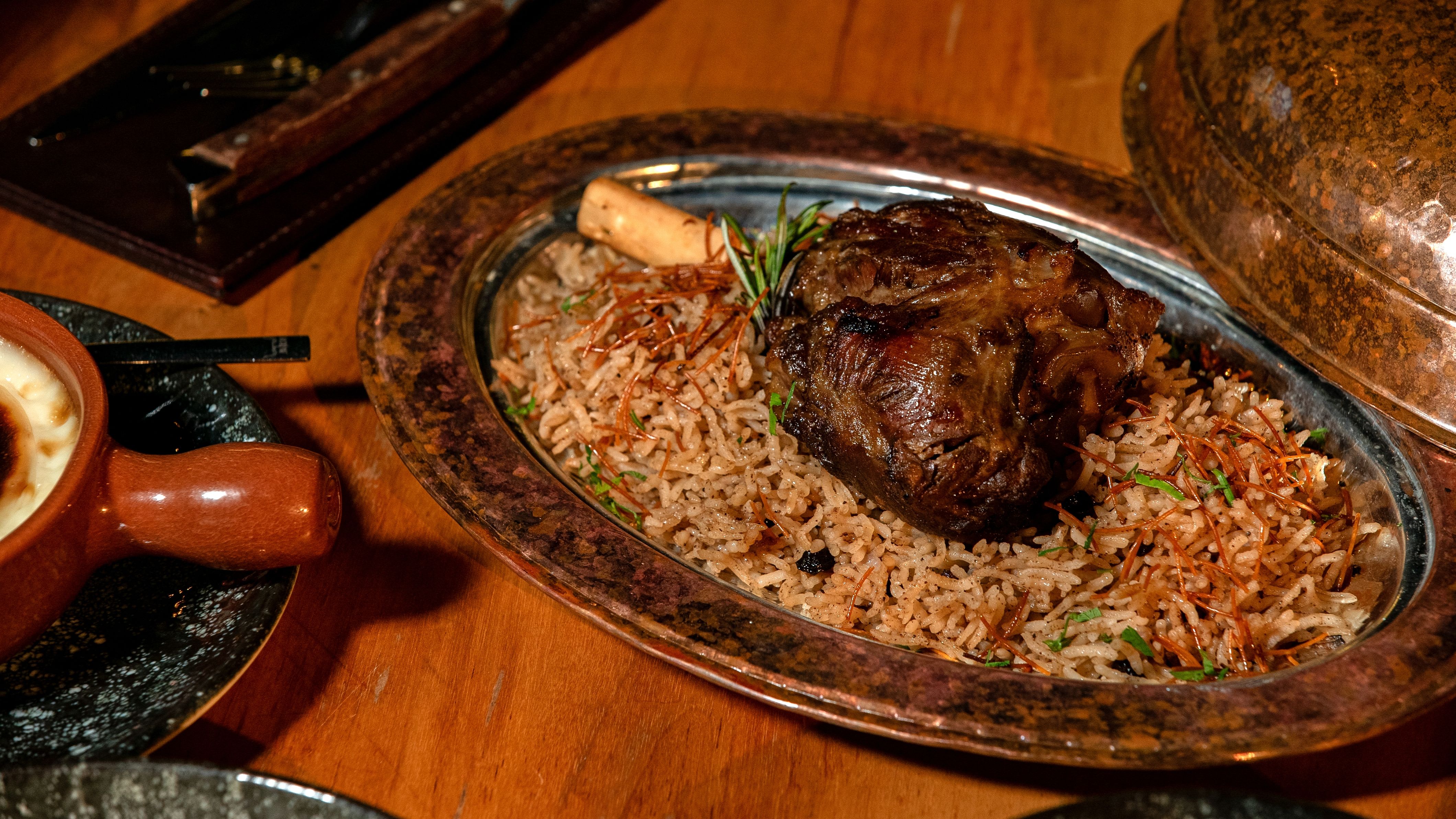 Aromatic lamb biryani served on a copper platter, rich in flavor and spices.