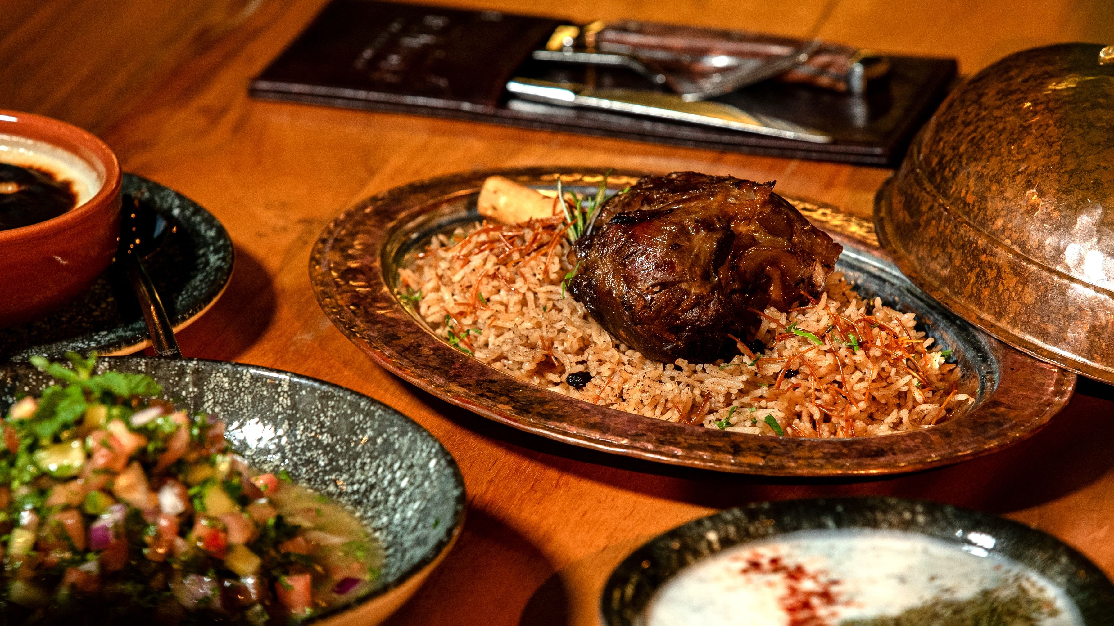Delicious Middle Eastern lamb dish with flavorful rice and fresh salad, perfect for a gourmet dining experience.