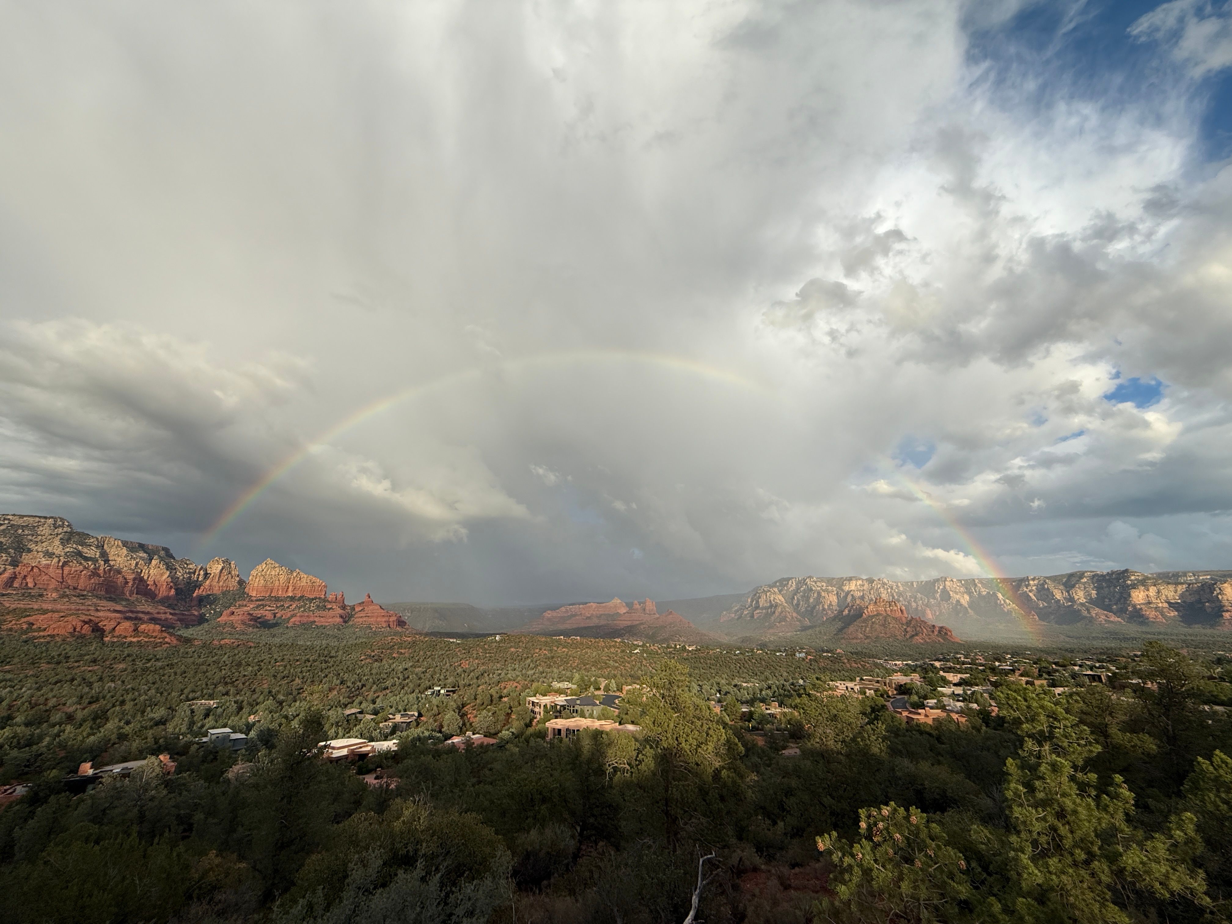 Unbeatable Everything Sedona (20+ Mile) - Sedona Helicopter Tour Review Review 2026 - Captivating view of a rainbow arching over Sedona's iconic red rocks and lush landscape.