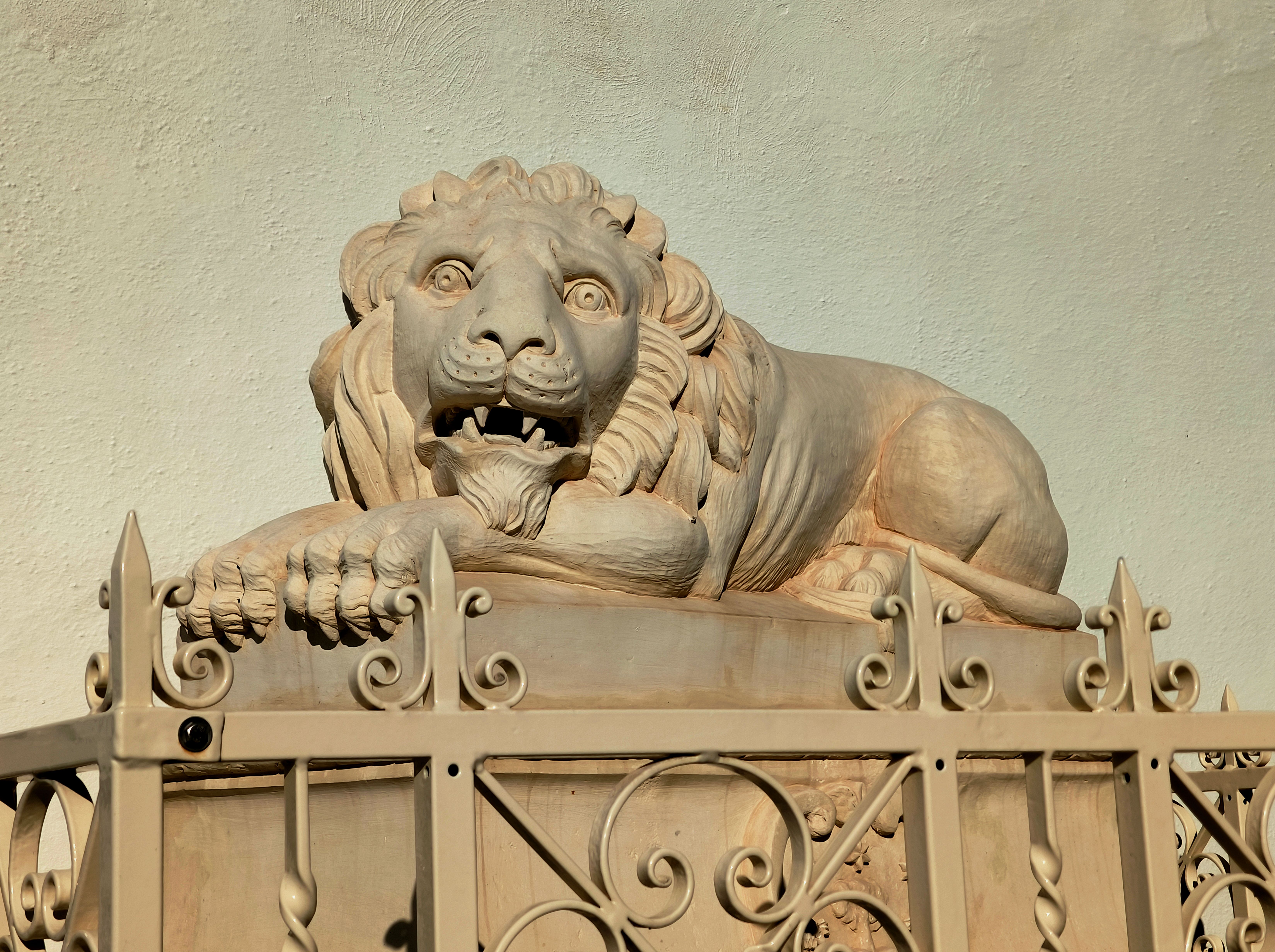 Majestic Stone Lion Sculpture on Fence · Free Stock Photo