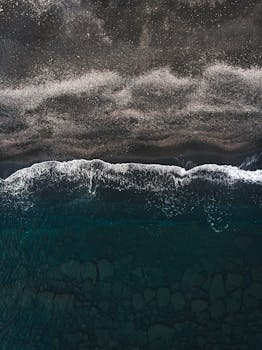 从空中俯瞰，海浪拍打原始海滩的景象令人惊叹，充分展现了大自然的美丽