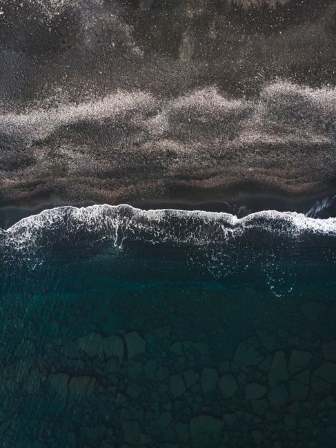 Stunning aerial view of waves crashing on a pristine beach, showcasing nature's beauty from above.