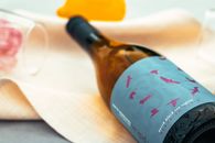 Close-up of a wine bottle with artistic label and glasses, perfect for lifestyle photography.