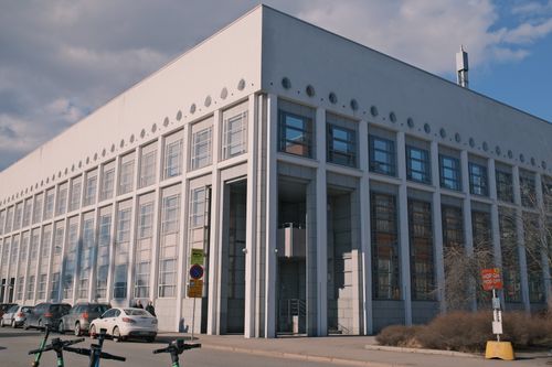 Free A modern, geometric building with multiple windows on a city street corner, captured during the day. Stock Photo