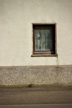 Simple urban window on a textured wall, capturing minimal architectural detail and atmosphere.