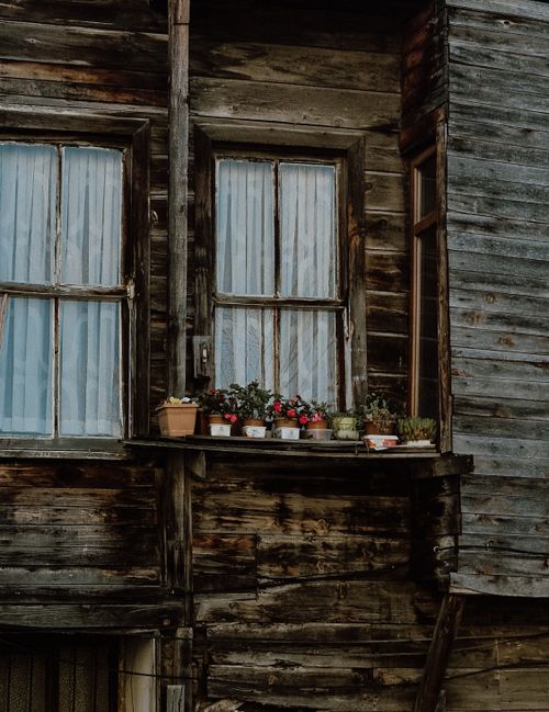 Free Charming rustic wooden house facade with potted flowers on window ledge in İstanbul. Stock Photo