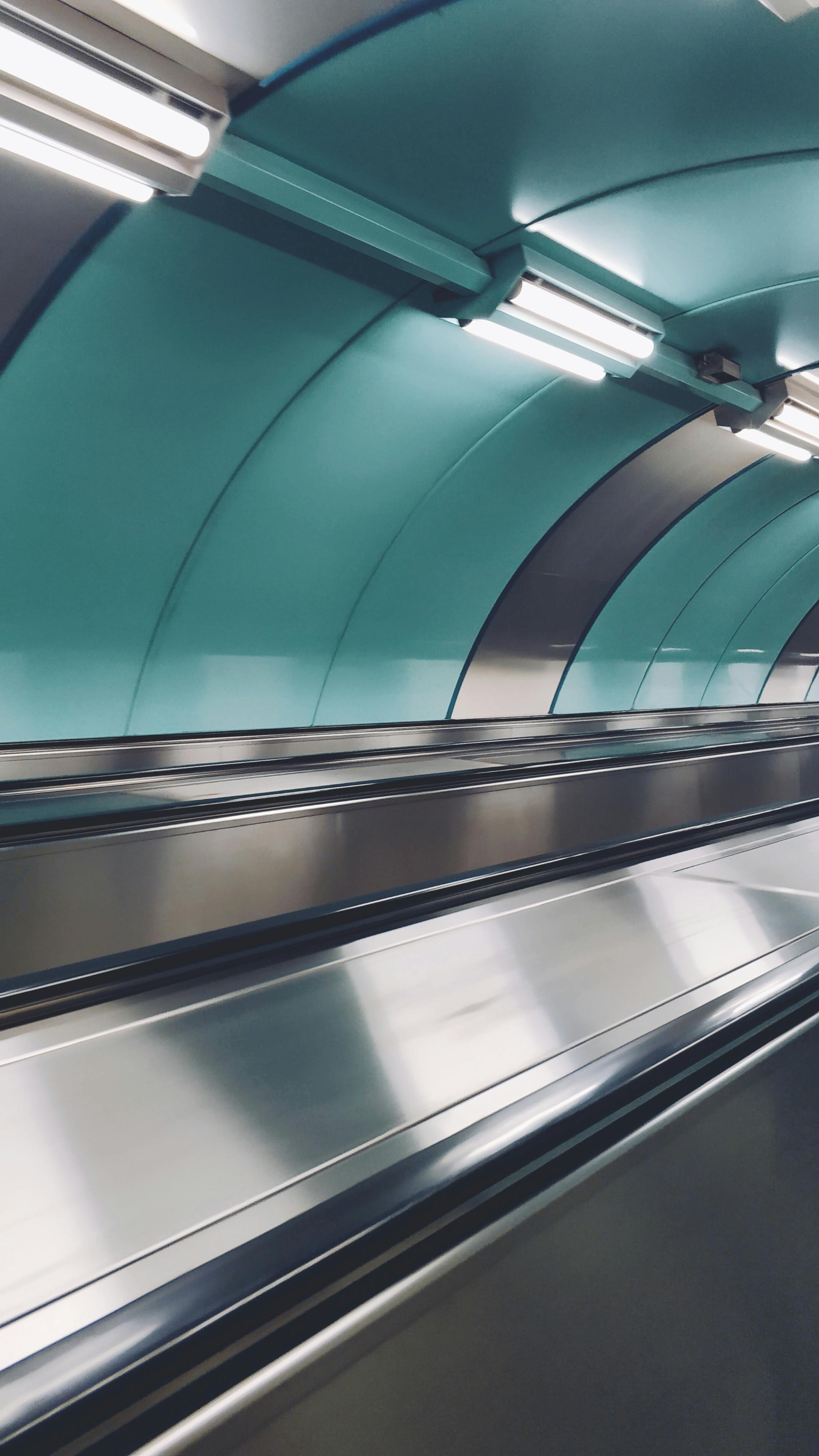 gray and green tunnel with lights