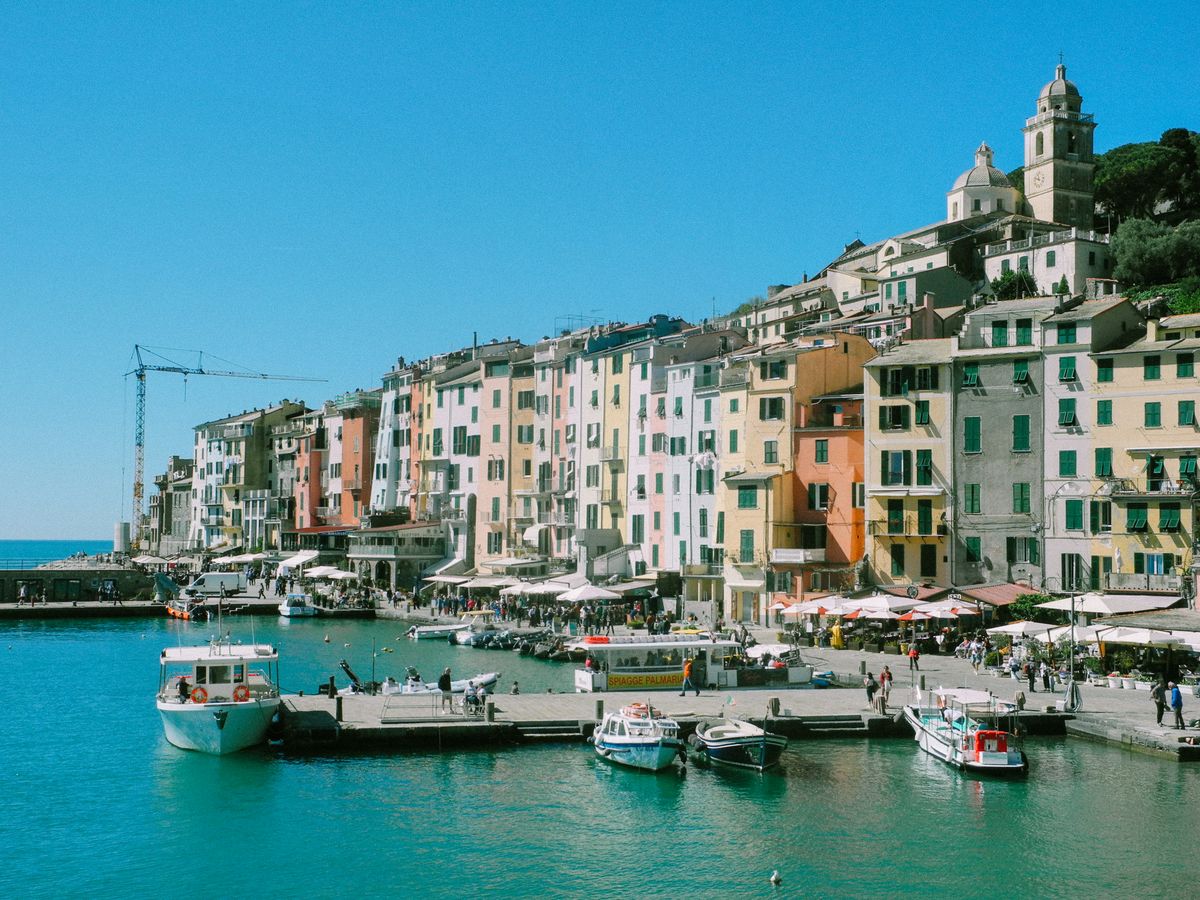 Vibrant harborside scene in Portovenere, Italy with colorful buildings and boats.