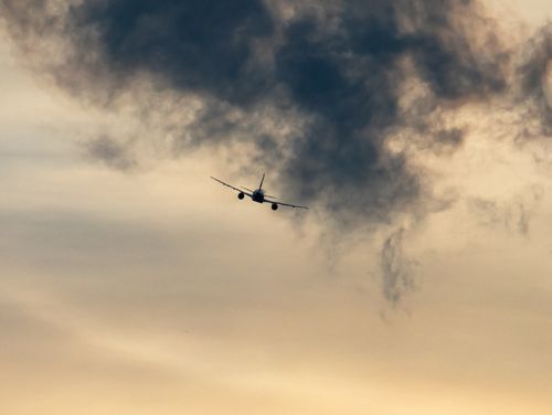 Free An airplane soars through a dramatic cloudy sky, creating a vivid scene in the atmosphere. Stock Photo