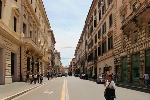 A bustling street scene in Rome's historic district lined with classic architecture.