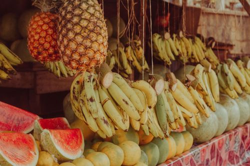 Free Colorful display of fruits including bananas, pineapples, and watermelons in Zaria City market. Stock Photo