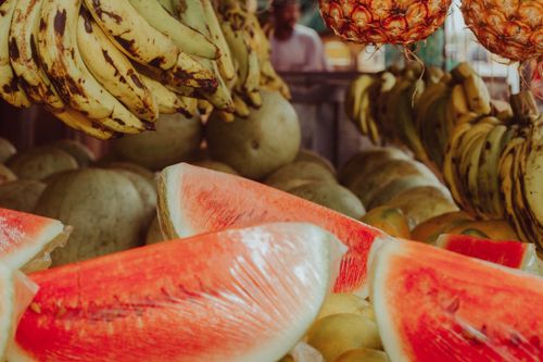 Free Vibrant display of bananas, watermelon, and pineapple at a street market in Zaria City, Nigeria. Stock Photo