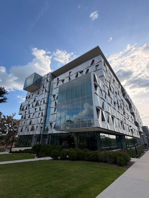 Free Contemporary building with a unique geometric facade and glass windows under a blue sky in Gainesville, FL. Stock Photo