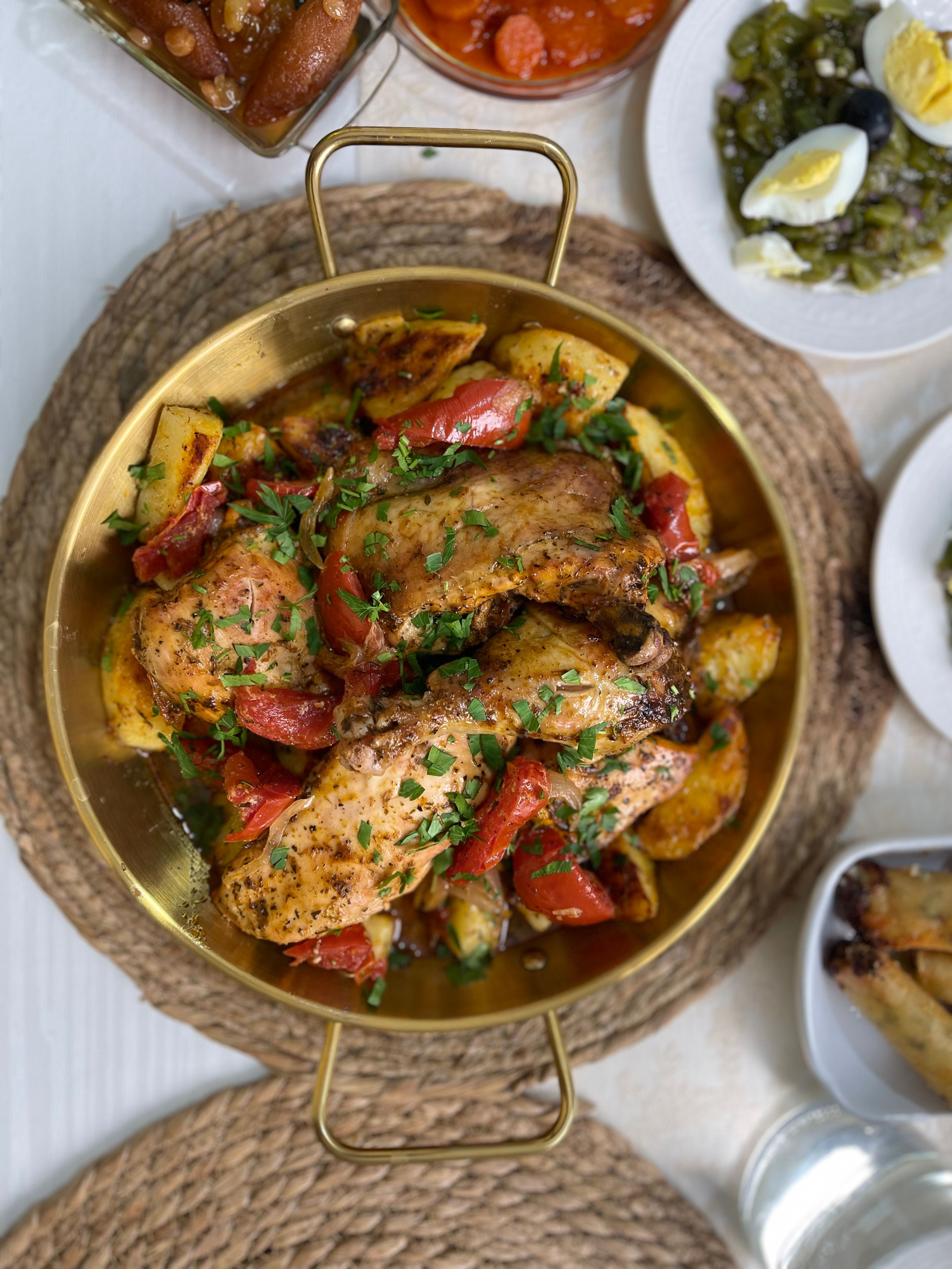 Golden roasted chicken with herbs and vegetables in a brass pan, perfect for a hearty meal.