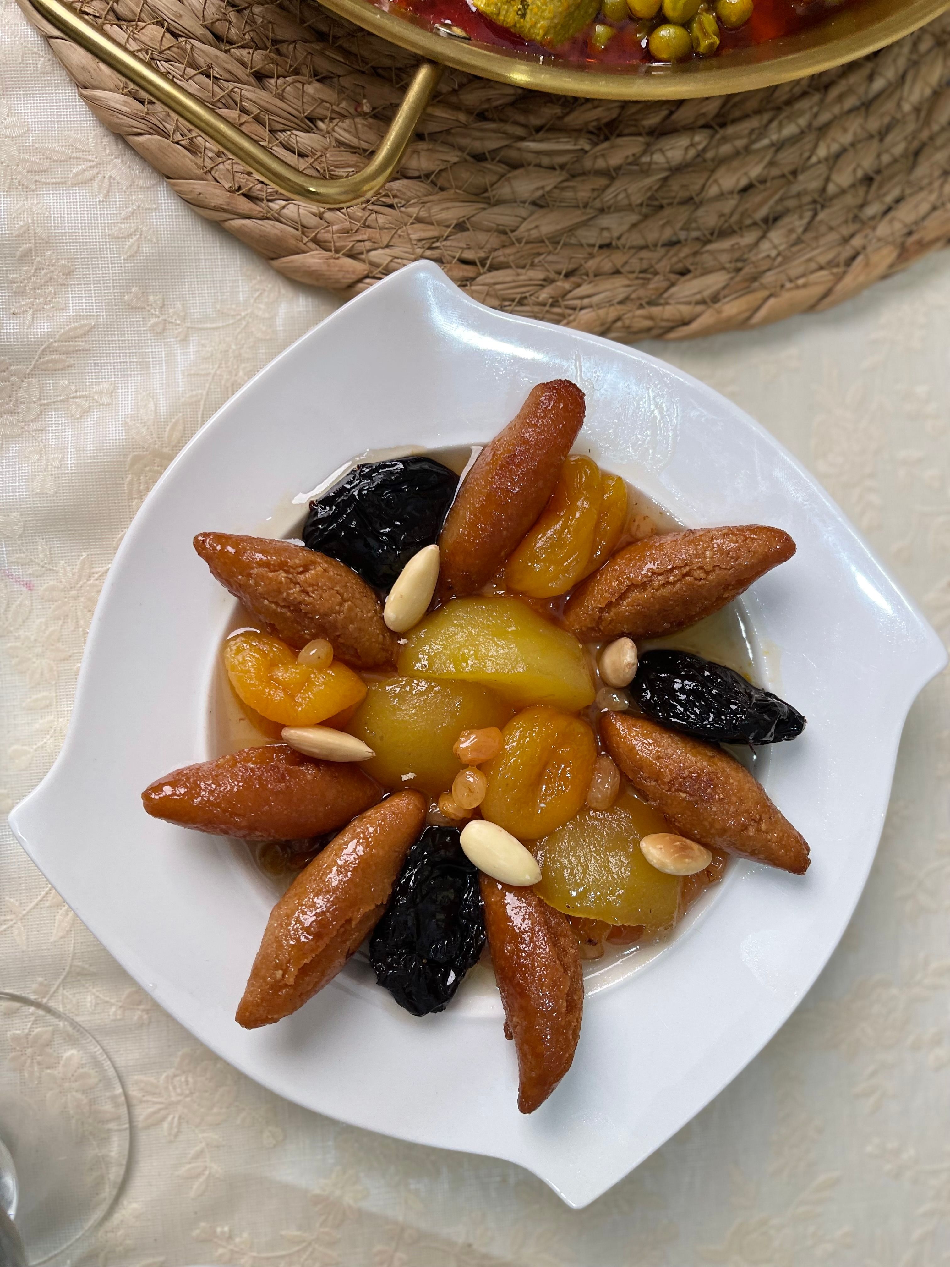 Top view of a traditional Algerian dessert featuring dried fruits and nuts, beautifully arranged on a white plate.