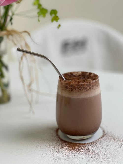 Free Refreshing iced mocha topped with foam and served with a metal straw, perfect for a cool treat. Stock Photo