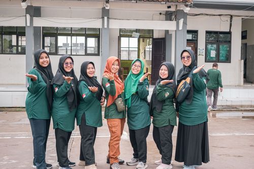 Free A group of cheerful women in uniform shirts posing outdoors with smiles and welcoming gestures. Stock Photo