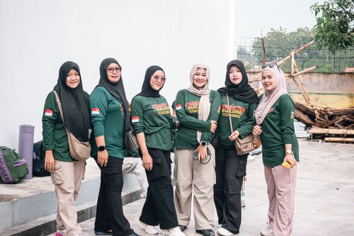 Free Six women in green outfits gather for a character building activity outdoors, showing camaraderie and unity. Stock Photo