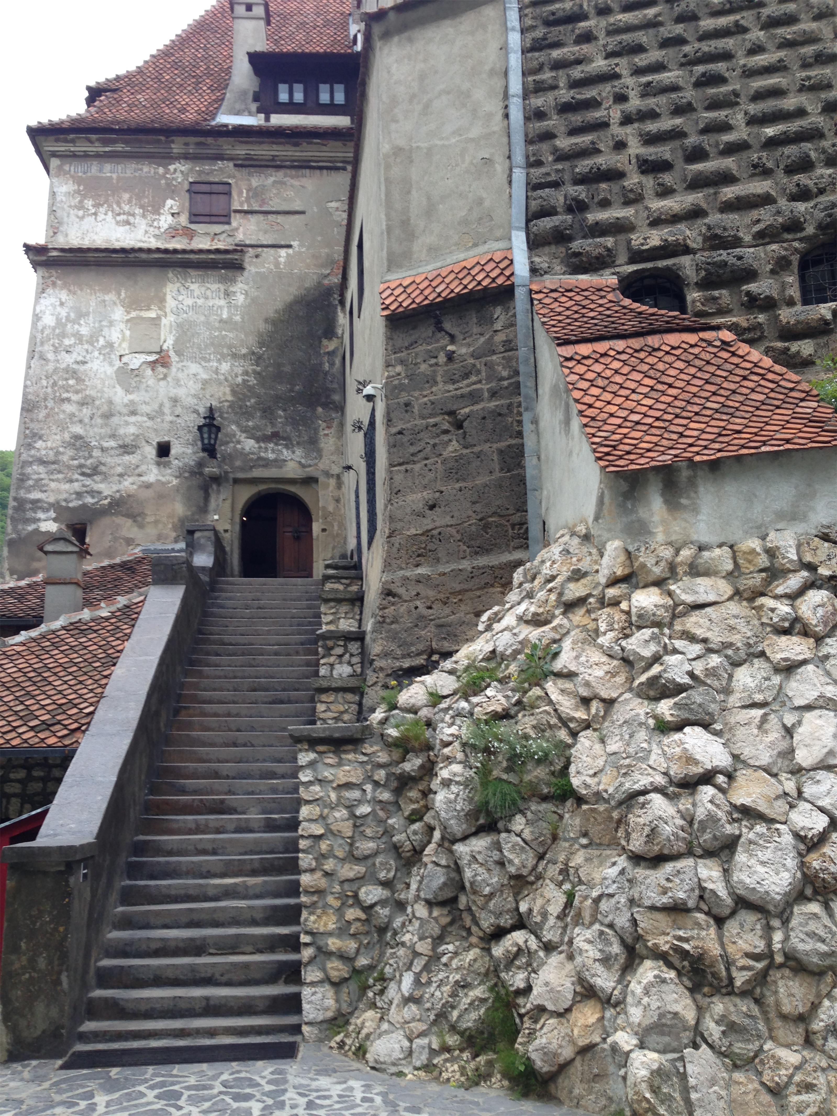 Explore the rustic charm of a historic Romanian castle with stone stairs and aged walls.