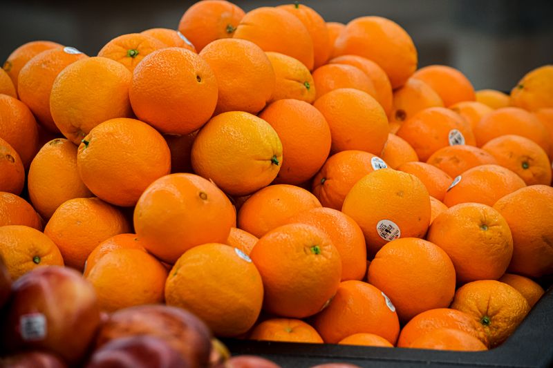Stacked fresh oranges at market