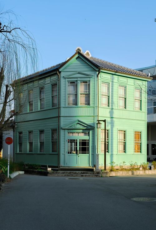 Free A quaint green wooden house in an urban area, embodying vintage architecture. Stock Photo