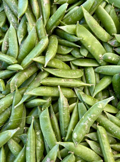 Free A vibrant and fresh display of sugar snap peas captured from above at a local market. Stock Photo