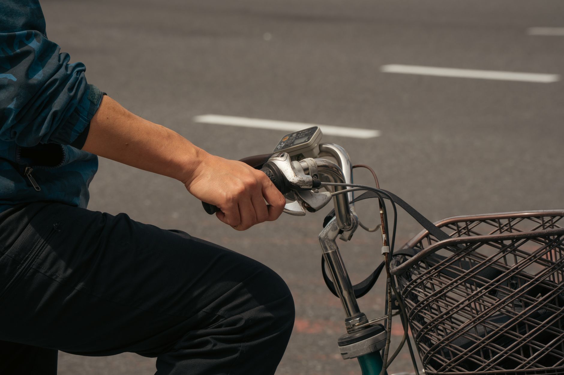 A close-up of a person riding a bicycle on a city street in Tokyo, Japan.