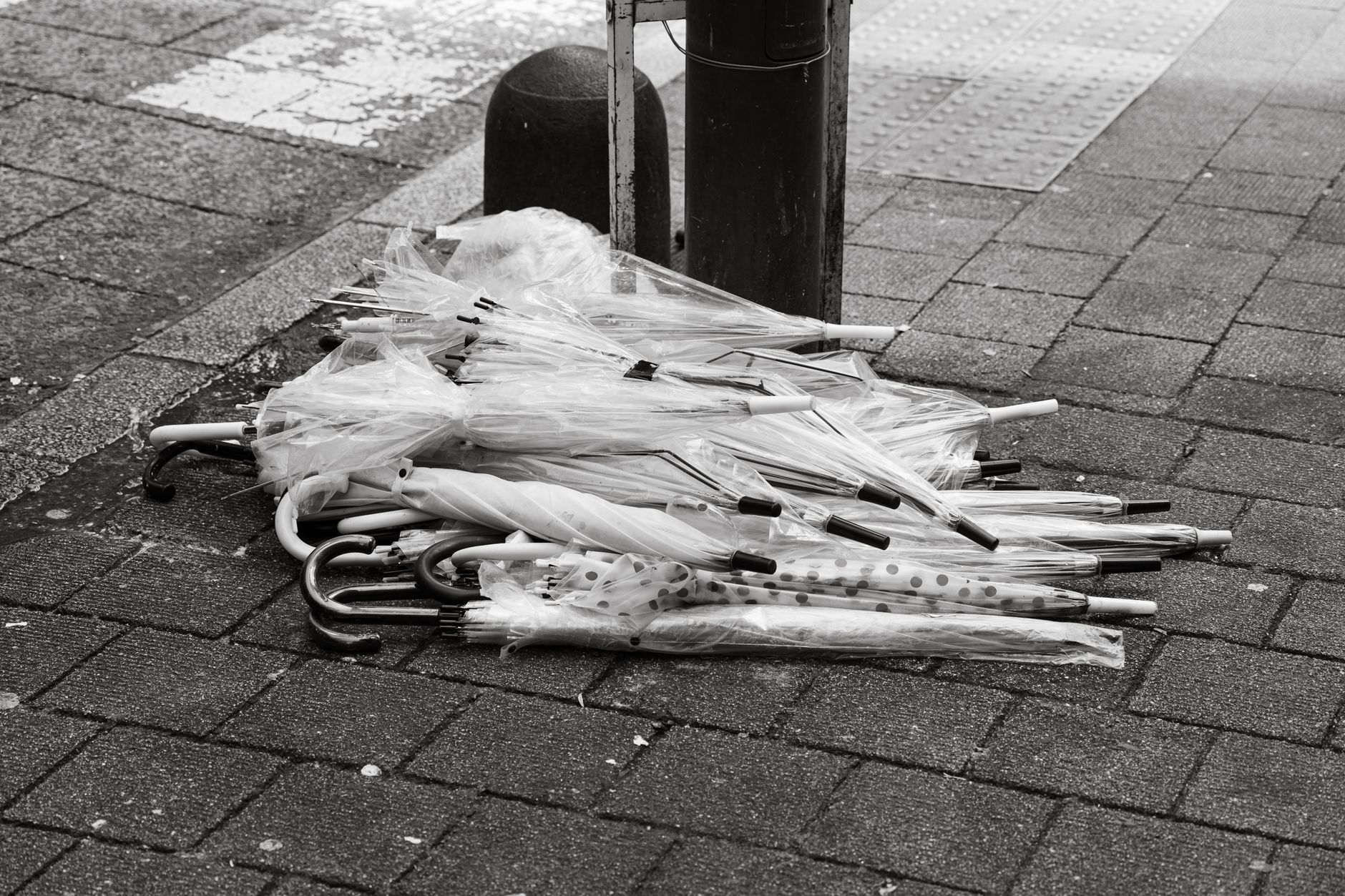 A pile of clear plastic umbrellas left on a street corner in Tokyo, Japan.