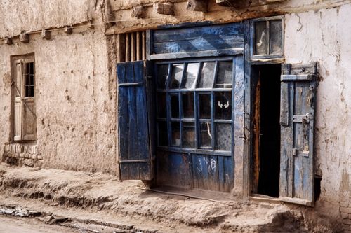 Free A weathered blue door on an ancient building in a rural Chinese village, showing rustic charm. Stock Photo