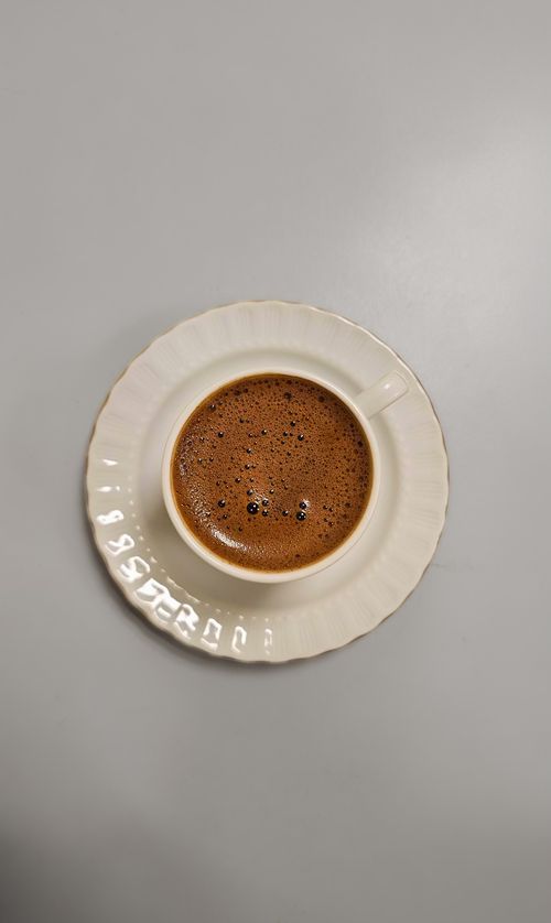 Free Delicious traditional Turkish coffee in a classic white cup on a light gray background. Perfect beverage shot. Stock Photo