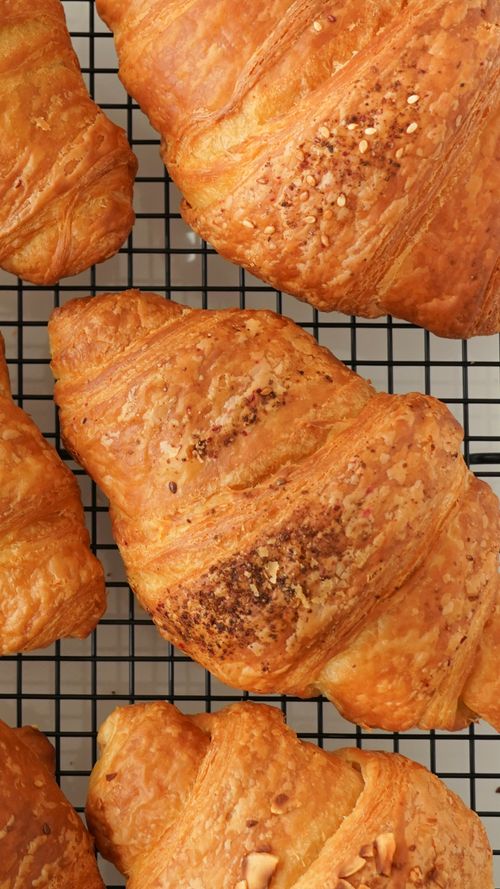 Free Golden brown croissants cooling on a wire rack, showcasing bakery perfection. Stock Photo