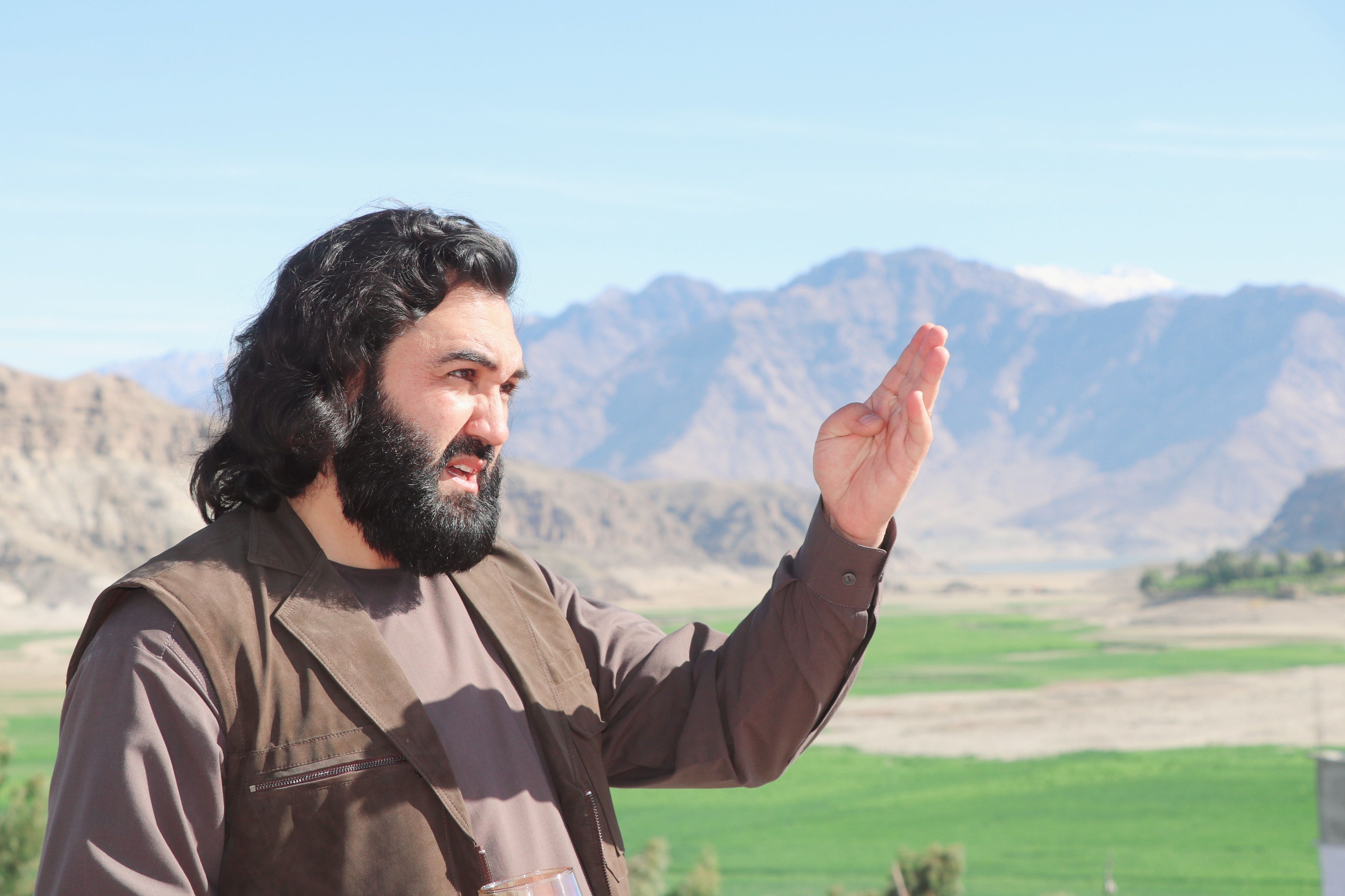 Man Gesturing Outdoors in Mountainous Landscape