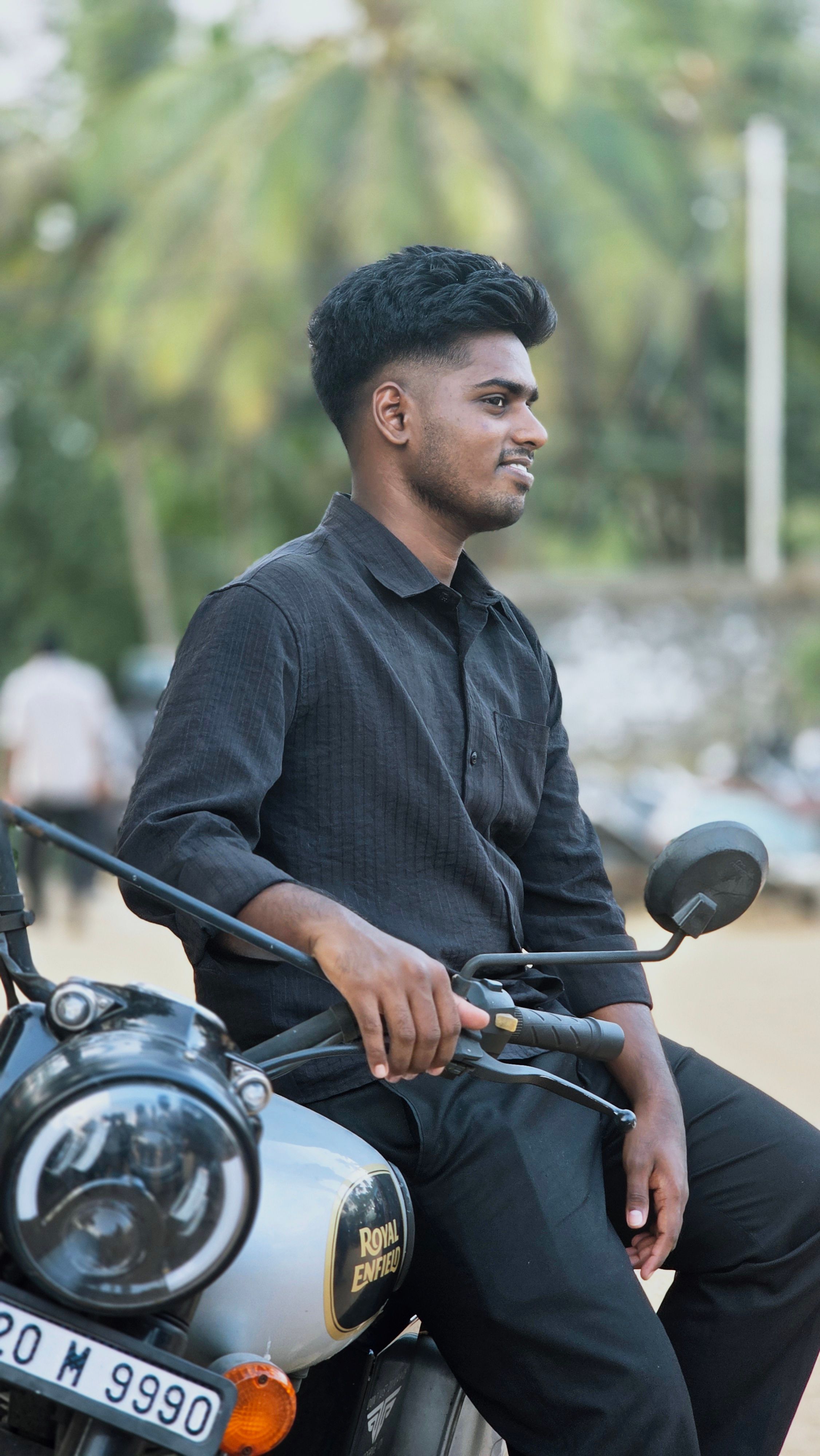 Young man sitting on a motorcycle outdoors, exuding a relaxed vibe.