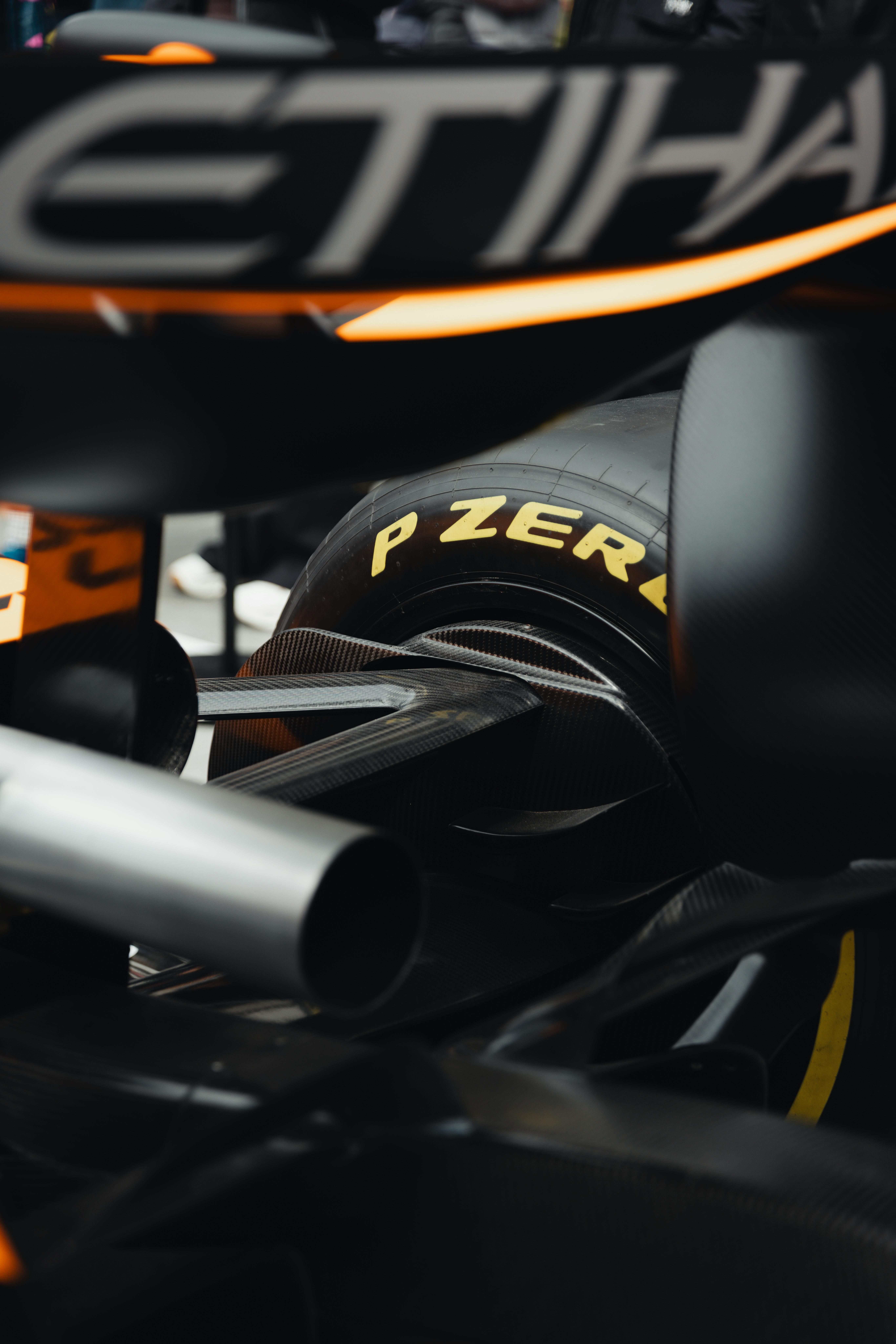 Detailed view of a racing car's rear showing Pirelli P Zero tires and aerodynamic features.