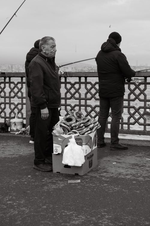 Free A black and white photo of a simit vendor on a bridge in Istanbul, Türkiye. Stock Photo