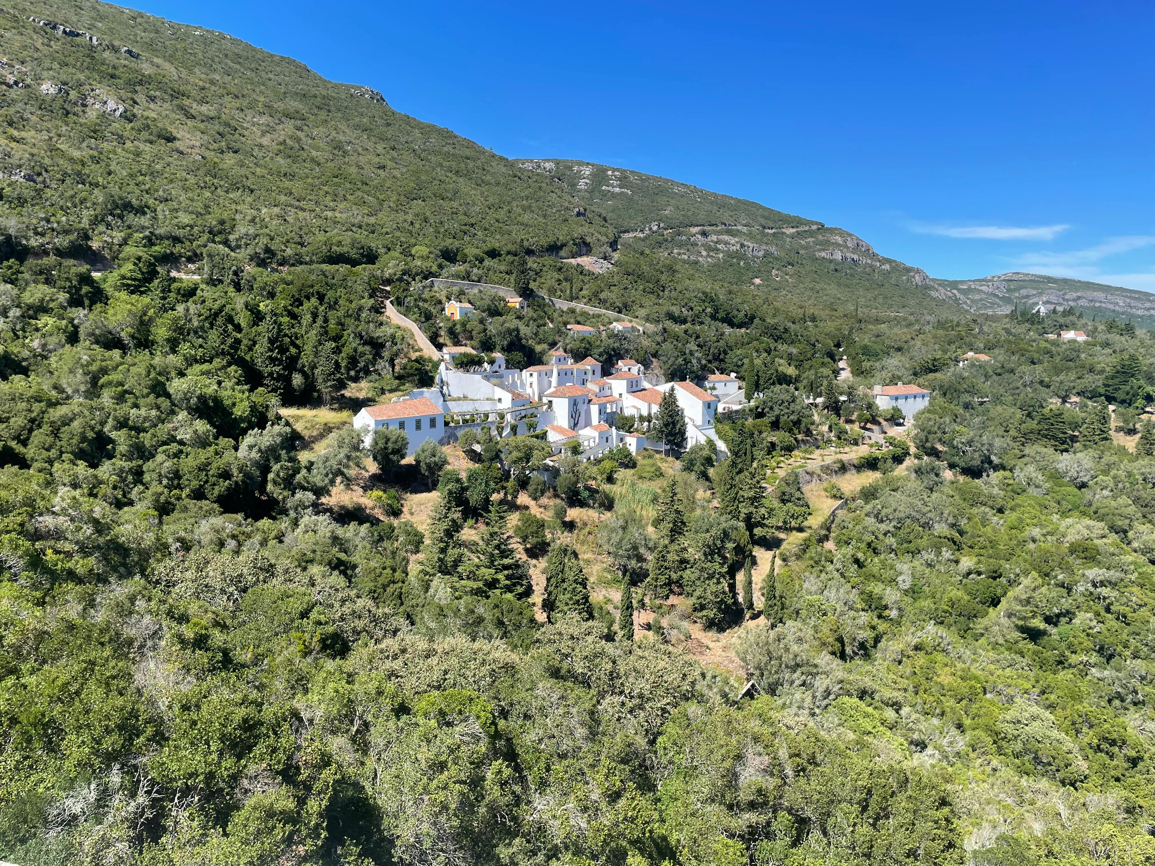 Aerial view of a charming mountain village nestled in Setúbal, Portugal surrounded by lush greenery.