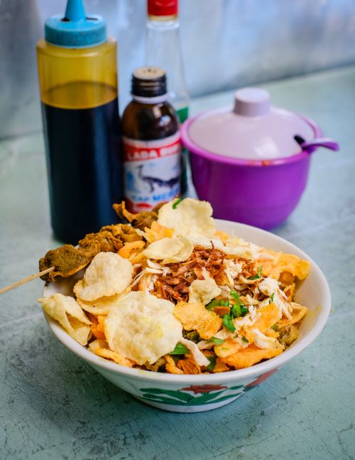 Free Authentic Indonesian Bubur Ayam served with condiments in Jakarta, showcasing vibrant flavors and textures. Stock Photo