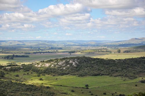 Free Aerial view of the picturesque hills and fields in Lavalleja, Uruguay with a clear blue sky. Stock Photo