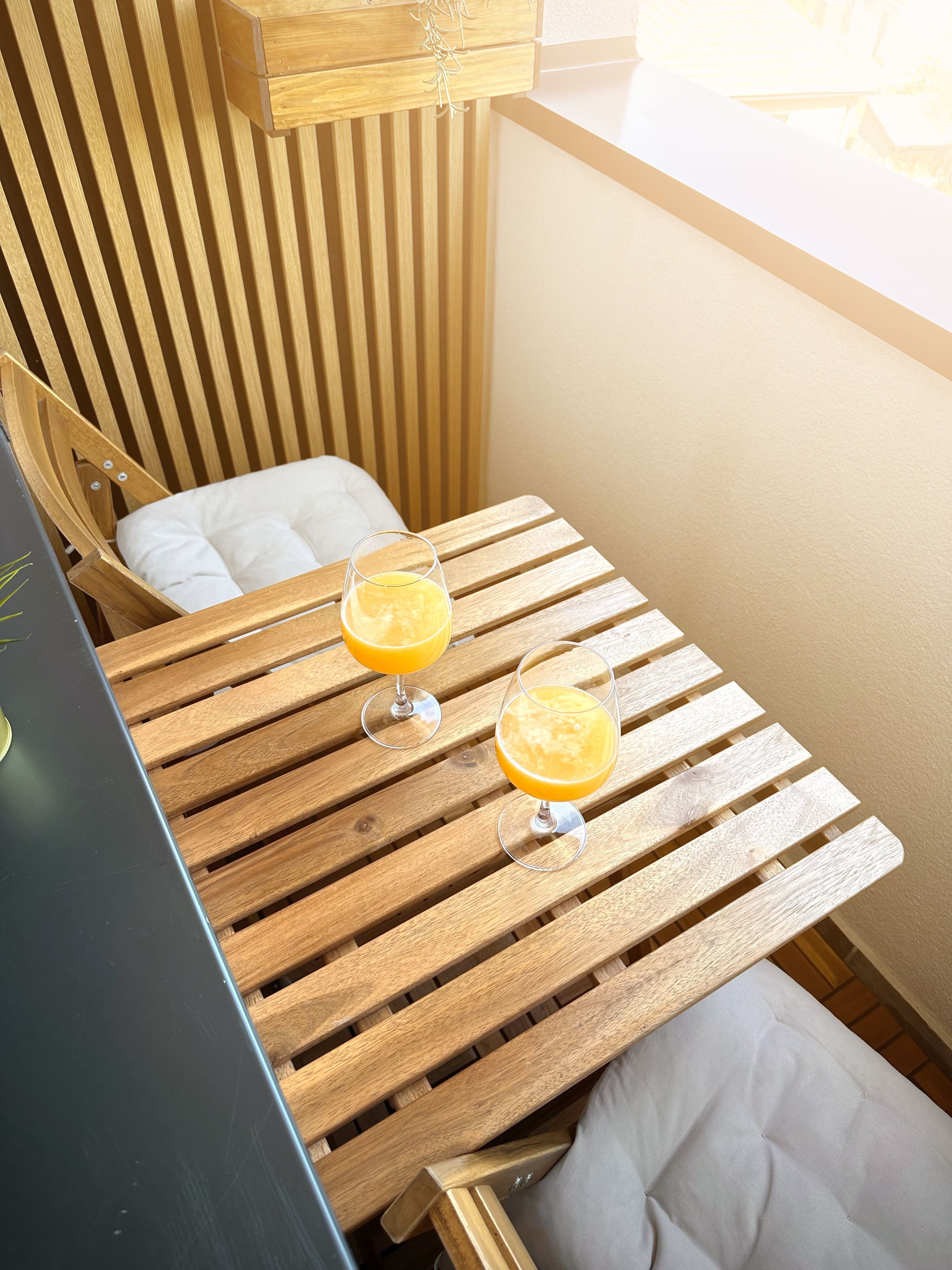 Low-pile weatherproof outdoor rug on a tiny apartment patio with a bistro set on top