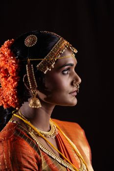 Profile portrait of an Indian bride in traditional attire with elegant jewelry.