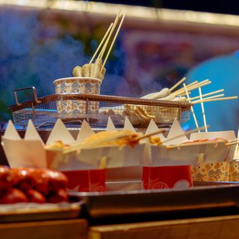 Steaming street food skewers at a vibrant night market in Manila, Philippines.