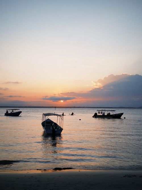 Free Tranquil boats float at sunset on Paraná's beautiful coastline, capturing nature's serene beauty. Stock Photo